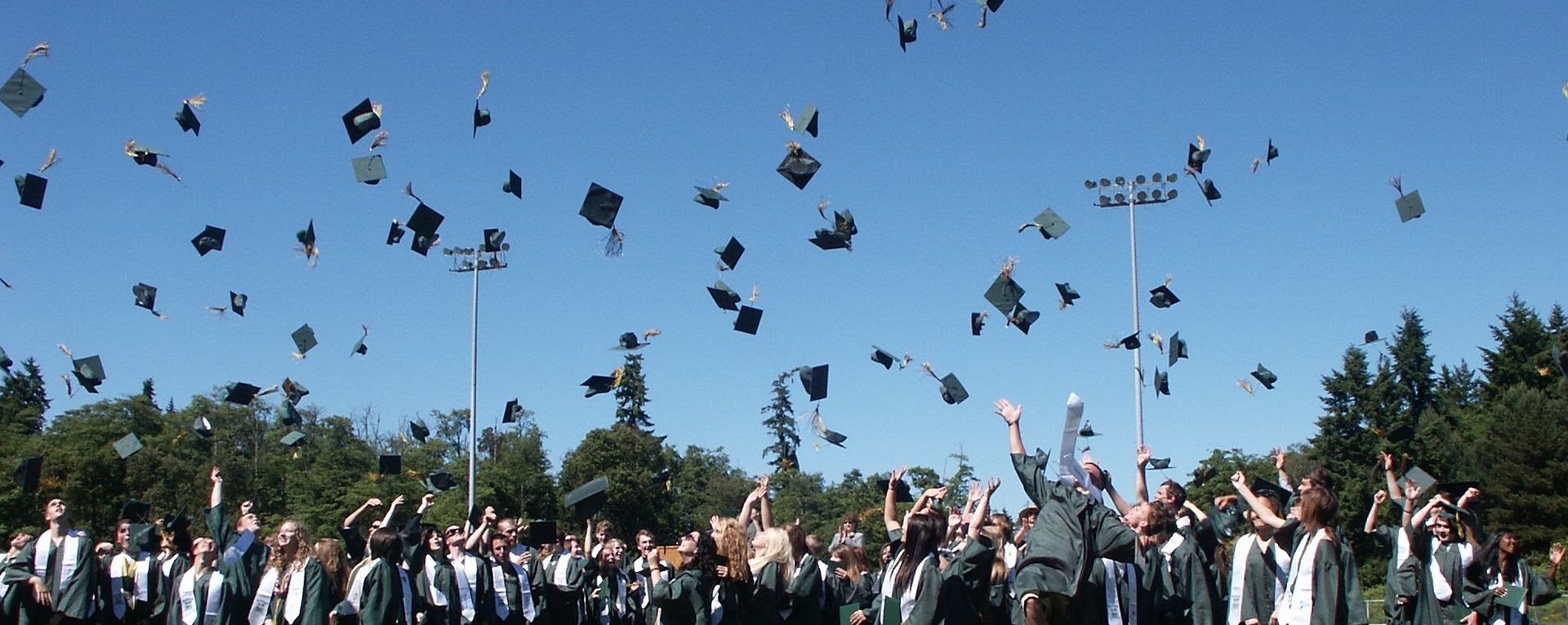 students throwing mortarboards at graduation